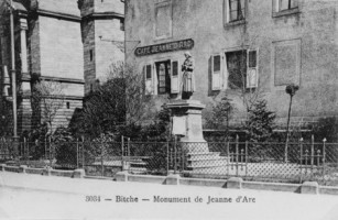 Au pied de l'église Sainte-Catherine, la statue de sainte Jeanne d'Arc veille sur la cité fortifiée. Ici photogaphiée au début du siècle, elle se situait devant le " café Jeanne d'Arc ", qui a été détruit dans les années suivant la dernière guerre.