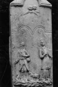 Saint Wendelin et une sainte femme sont représentés sur le fût, dominés par deux têtes d'angelots ailées (photographie du service régional de l'inventaire de Lorraine).