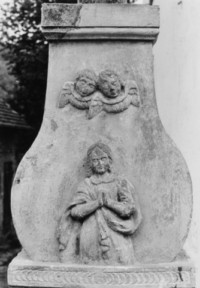 Sur le registre supérieur du fût, le buste d'une sainte femme est surmonté de deux têtes d'angelots ailées (photographie du service régional de l'inventaire de Lorraine).