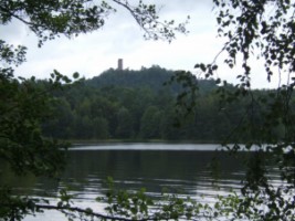 Les eaux paisibles de l'étang de Waldeck et la silhouette du château du même nom.