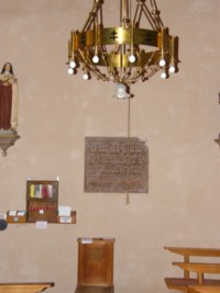 Une inscription sculptée dans une plaque de grès, encastrée dans le mur Ouest de la chapelle, est écrite en allemand gothique.