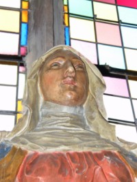 Le visage serein de la Sainte Vierge Marie est encadré par un petit voile court.
