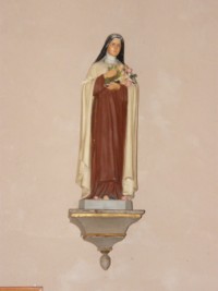 Une statue moderne de sainte Thérèse de l'Enfant-Jésus est située contre le mur Ouest de la chapelle.