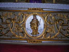 En bois peint, doré et argenté, le devant d'autel représente sans doute la Très Sainte Vierge, ainsi que des volutes feuillagées, des décors d'entrelacs et des cornes d'abondance d'où s'échappent des fleurs.