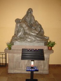 Une statue de la Vierge de Pitié est située sous la tour-clocher.