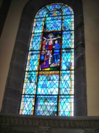 Un vitrail représente la Crucifixion de Notre-Seigneur.