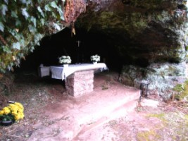 Un autel est érigé dans la grotte de Lourdes.