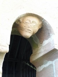 Différents visages grimaçants sont sculptés sur les arcades de l'ossuaire.