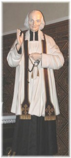 Une statue du saint Curé d'Ars est installée au pied de l'autel latéral droit.
