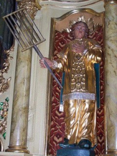 La statue de saint Laurent est placée dans une niche, qui encadre le tabernacle tournant du maître-autel.