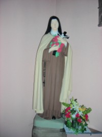 Une statue de sainte Thérèse de l'Enfant-Jésus et de la Sainte-Face est située au fond de l'édifice.