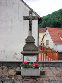 Une croix est érigée à proximité de la grotte de Lourdes.