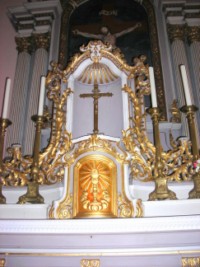 La croix d'autel est située dans la niche qui domine le tabernacle.