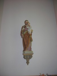 Une statue de saint Joseph portant l'Enfant-Jésus dans ses bras domine l'autel latéral droit.