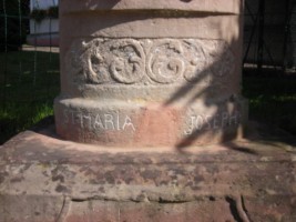 Une frise de motifs végétaux occupe la base du fût-stèle.