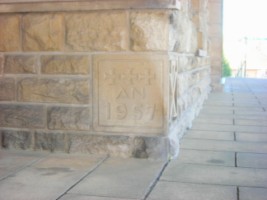 Sous les arcades du porche, la pierre de fondation de l'édifice demeure visible.