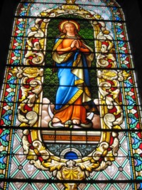 Un vitrail représente l'Immaculée Conception de la Sainte Vierge.