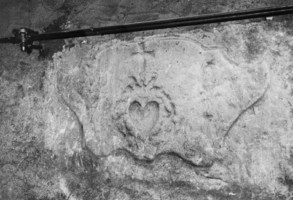 Provenant très vraisemblablement de l'ancien ossuaire, une pierre sculptée est remployée dans la maçonnerie de la sacristie.
