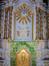 Le tabernacle est surmonté d'une niche d'exposition, encadrée par quatre colonnes torsadées.