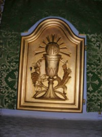 Le tabernacle du maître-autel représente le thème de la Sainte Eucharistie.
