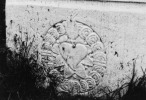 Un cœur enflammé dans une gloire occupe la face du socle de la croix (photographie du service régional de l'inventaire de Lorraine).