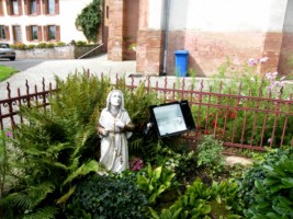 Une petite statue de sainte Bernadette, agenouillée aux pieds de la Sainte Vierge, complète l'ensemble.