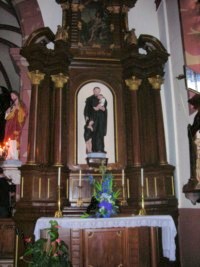 Une statue de saint Vincent de Paul trône sur l'autel latéral droit.