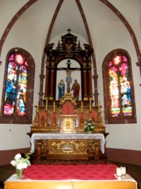 Le maître-autel est surmonté d'un retable et du groupe de la Crucifixion.