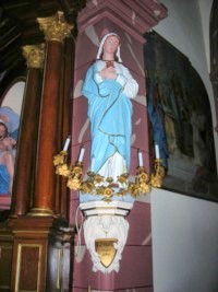 Une statue du Cœur Immaculé de Marie est située à gauche de l'arc triomphal.