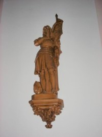 Une statue en plâtre de sainte Jeanne d'Arc est située contre le mur Ouest de la nef.