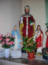 La statue d'un saint évêque est située à gauche, de même que celles de la Sainte Vierge et du Sarcré-Cœur.