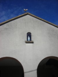 Une statue de Notre-Dame de Lourdes trône dans une niche de la façade.