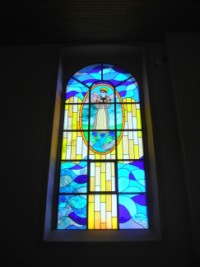 Un vitrail représente l'apparition de la Sainte Vierge à La Salette en 1846.