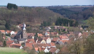 Panorama du village de Walschbronn, de l'église Saint-Benoît et des ruines du château du Weckersburg depuis la fromagerie.